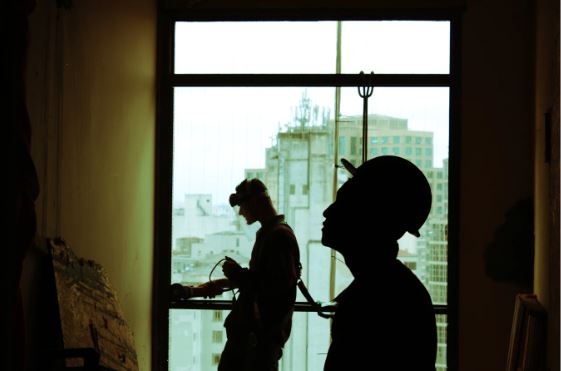 Two contractors at a fireplace installation site